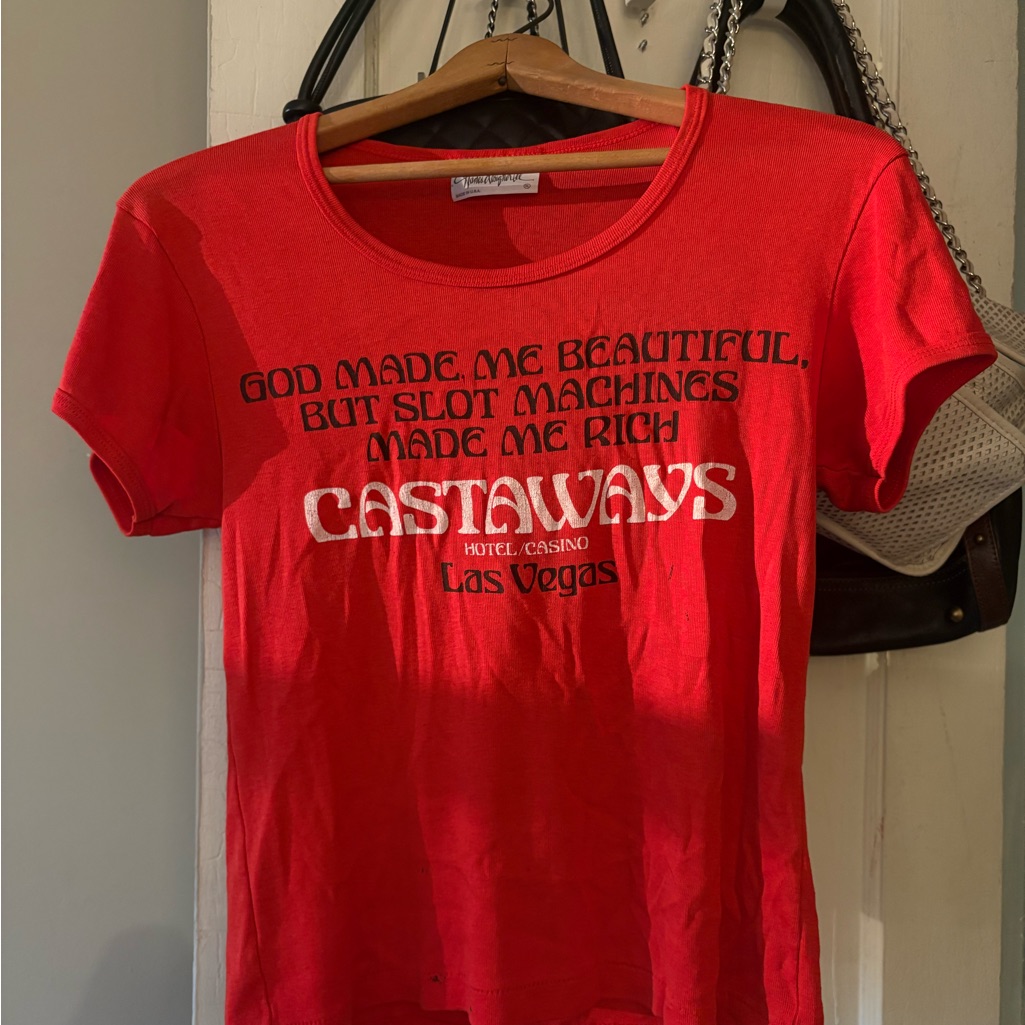 Red 1990s graphic baby tee on a hanger with a slogan print across the chest